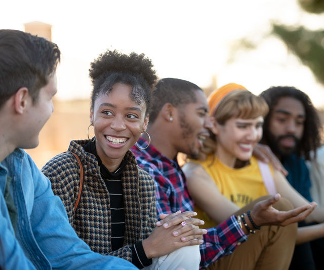 Female student interacting with a diverse group of friends