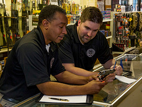 Two, male, ATF Industry Operation Investigators perform a compliance inspection at a gun store