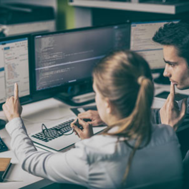 A man and woman looking at a computer screen as the woman points to the screen