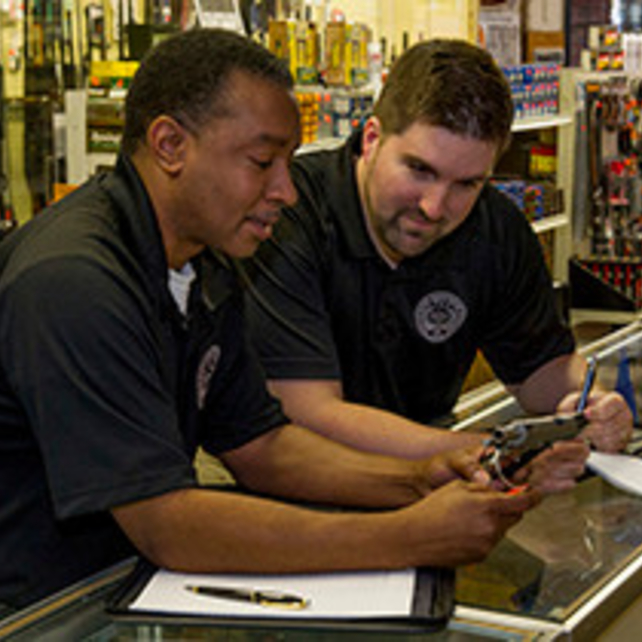 Two, male, ATF Industry Operation Investigators perform a compliance inspection at a gun store