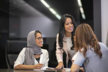 Group of female colleagues looking at each other and talking