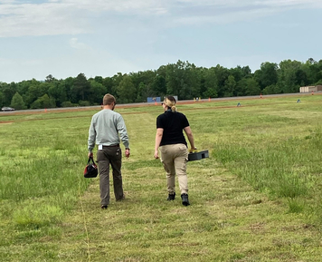 Sonia walking in a field with a colleague