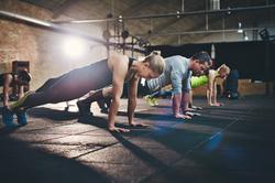 A group of people doing push ups in a small gym